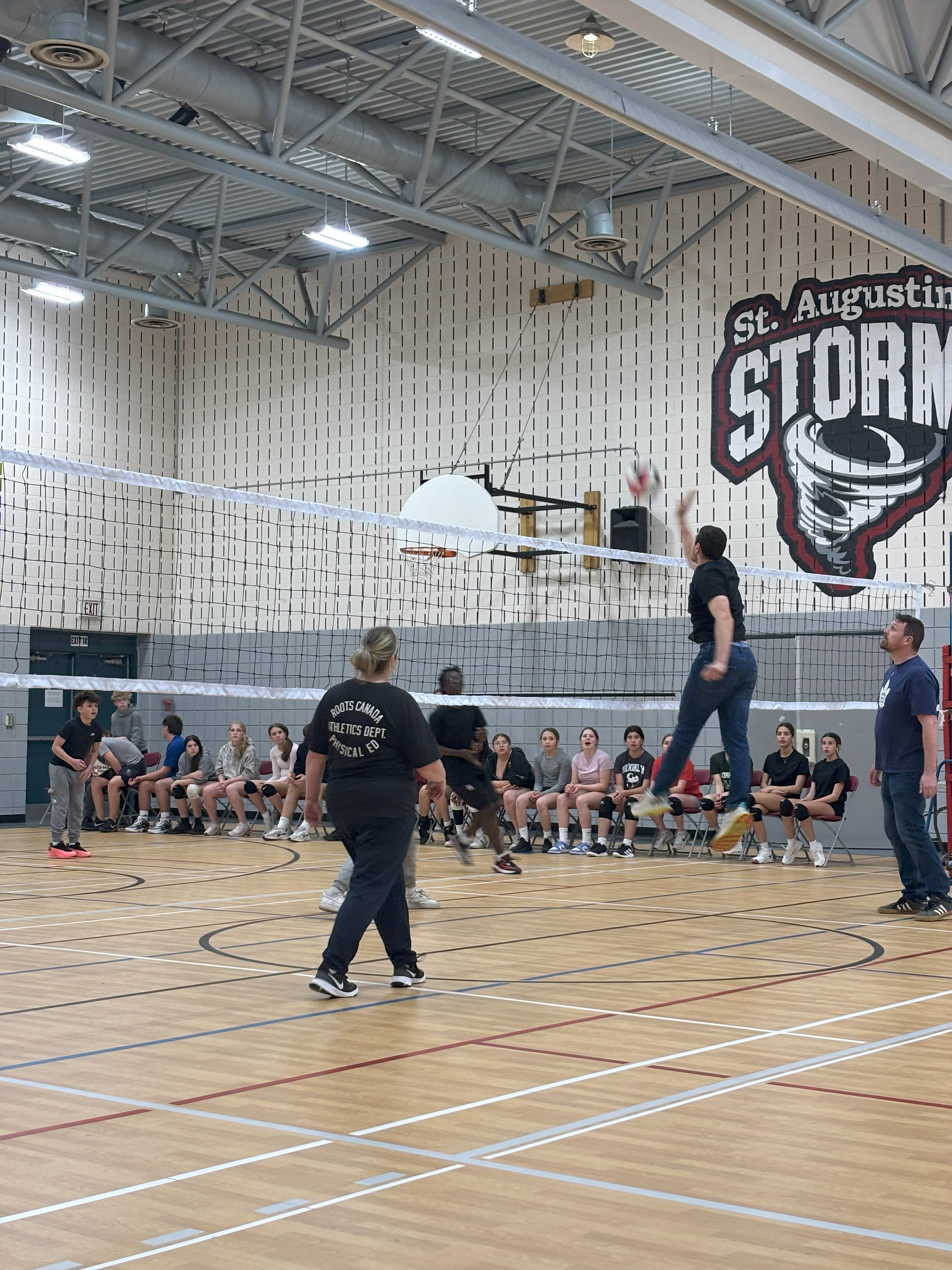 Teacher attempting to spike volleyball