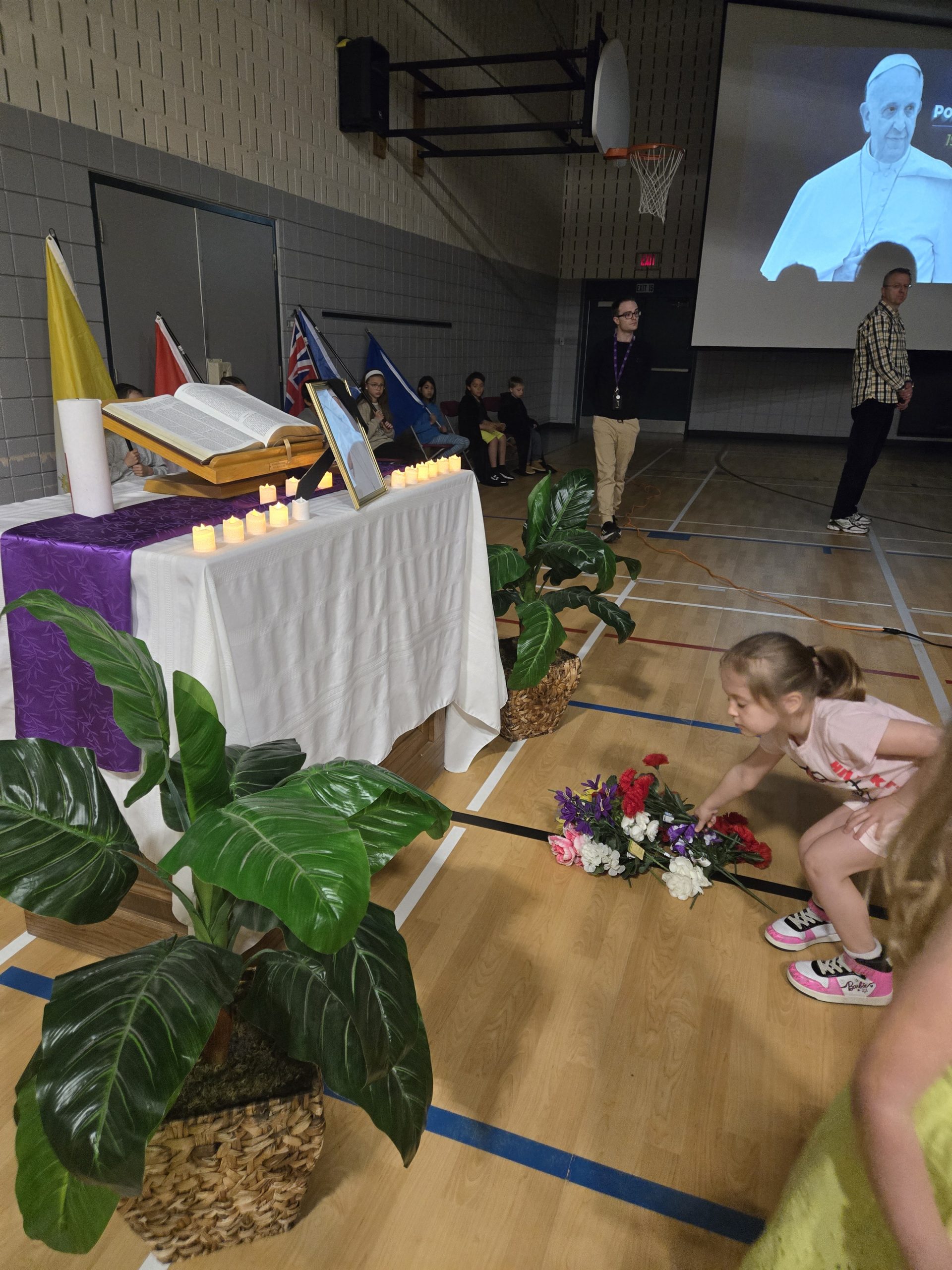 Student laying a flower in front of altar